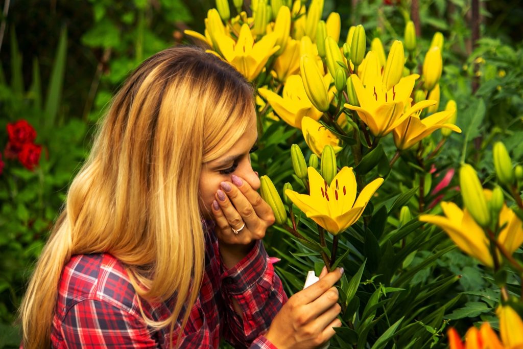 Serene image of a woman standing in a lush forest, gently smelling vibrant yellow flowers, symbolizing relief and rejuvenation from seasonal allergies, achieved through the Allergy Neutralizer IV Therapy offered at Revive and Drip Medical Spa. This therapy is designed to alleviate allergy symptoms, allowing individuals to fully enjoy the beauty of nature without the discomfort that allergies can bring. Revive and Drip provides a holistic approach to wellness, offering a comprehensive range of services including Botox, dermal fillers, aesthetic treatments, IV therapy, and weight loss solutions. The peaceful forest setting and the woman's relaxed expression emphasize the spa's commitment to creating a calming and luxurious environment where clients can find relief from allergies and achieve their health and beauty goals. The yellow flowers represent the natural, soothing ingredients used in the therapy, while the forest background underscores the connection between nature and wellness that is central to the spa's philosophy.