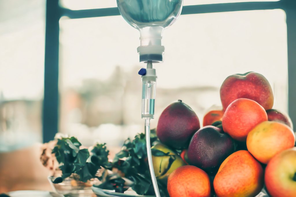 An IV Drip stands prominently in front of a vibrant pile of fresh fruit, symbolizing the nourishing and revitalizing benefits of IV Therapy available at Revive & Drip in Washington, PA. This striking image conveys the natural, health-boosting elements infused in Revive & Drip’s IV Therapy treatments, designed to hydrate and replenish the body with essential vitamins and minerals. The clinic’s offerings extend beyond IV Therapy, providing comprehensive wellness and aesthetic services, including Botox, fillers, and weight loss treatments, all aimed at enhancing your health and beauty. The fruit and IV combination serves as a visual metaphor for the rejuvenation and vitality clients can achieve through Revive & Drip’s tailored wellness solutions.