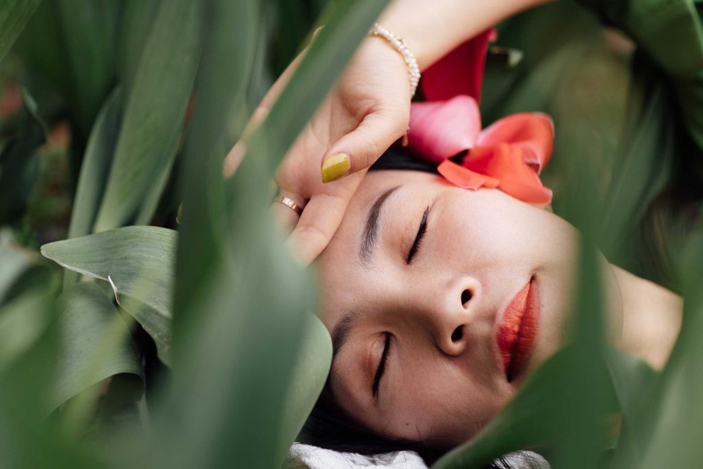 a woman lying down with her eyes closed